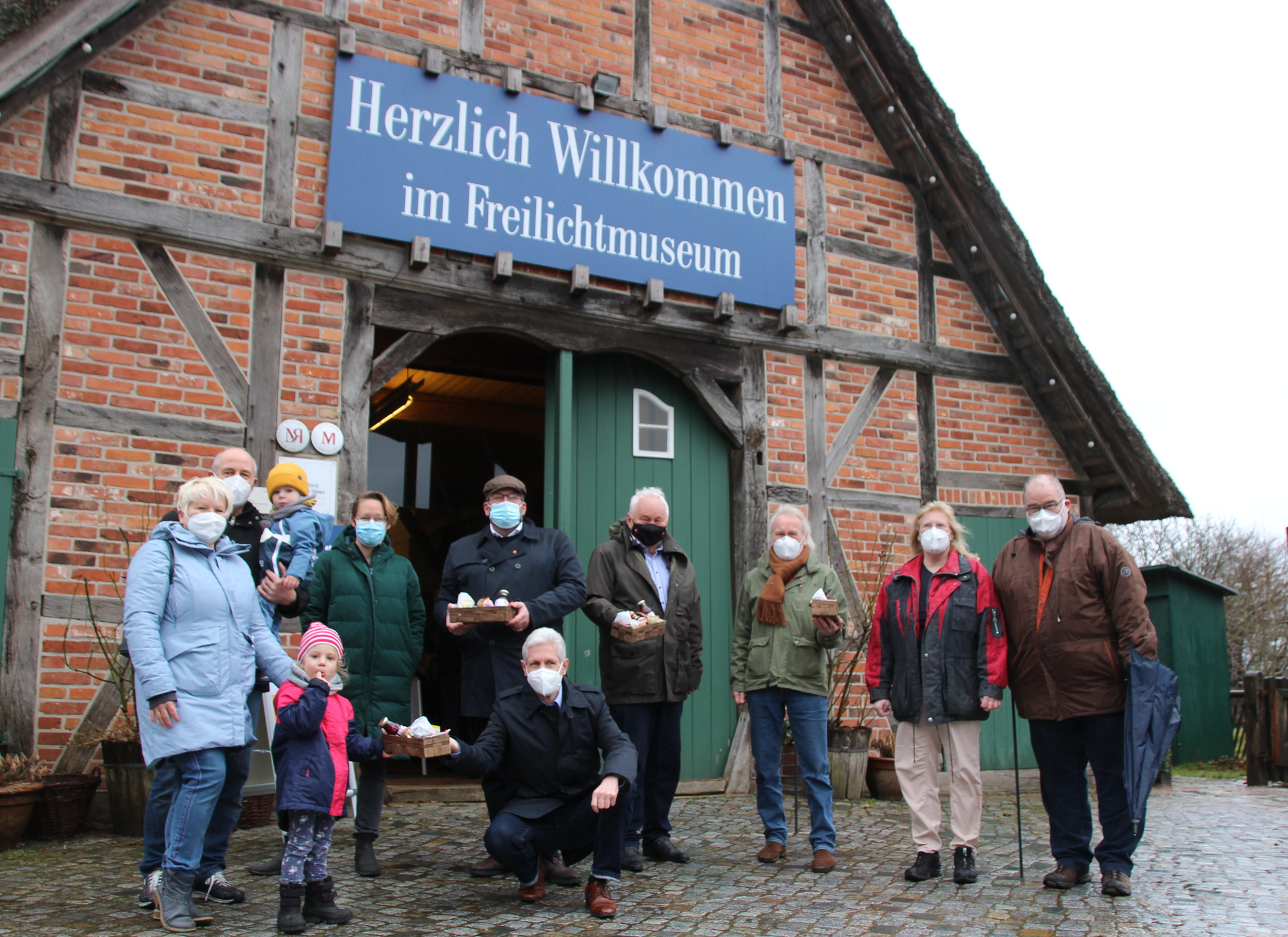FLMK -Die ersten Besucher am Kiekeberg werden in gelöster Stimmung begrüßt:Gunda und Rainer Holst mit ihren Enkelkindern Yannik und Luisa Landrat Rainer Rempe (vorn) Museumsleitung Carina Meyer und Stefan Zimmermann Heiner Schönecke Stiftungsratsvorsitzender Klaus-Wilfried Kienert Eva-Maria Ohde und Bernd Ritzenhoff vorm Eingang des Freilichtmuseums am Kiekeberg (v.l.)
